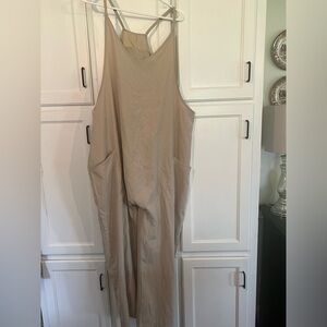 Tan romper with pockets and small zipper detail on back.